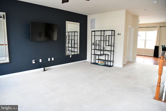 carpeted spare room featuring ceiling fan