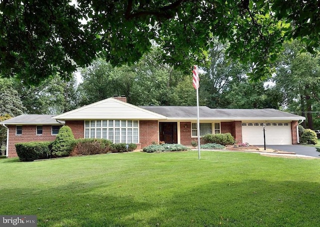 ranch-style house featuring a garage and a front lawn