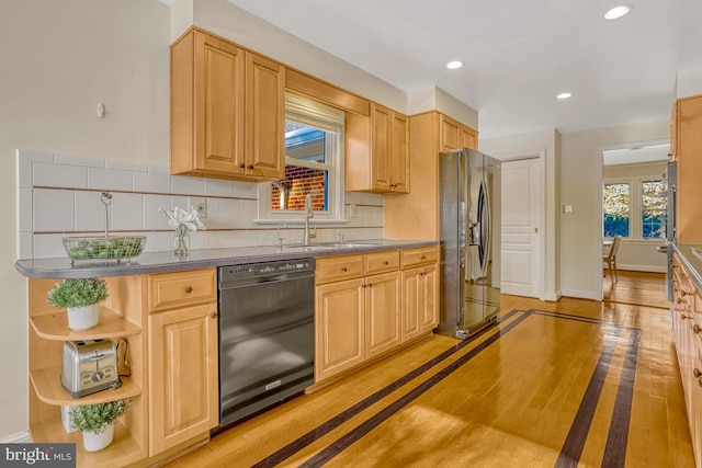 kitchen with backsplash, light wood-type flooring, black appliances, and light brown cabinets