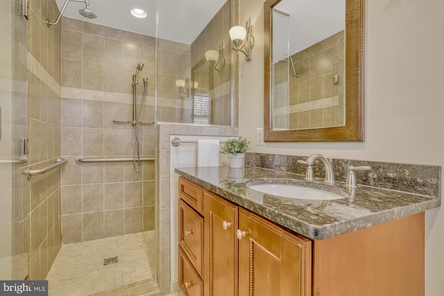 bathroom featuring tiled shower and vanity