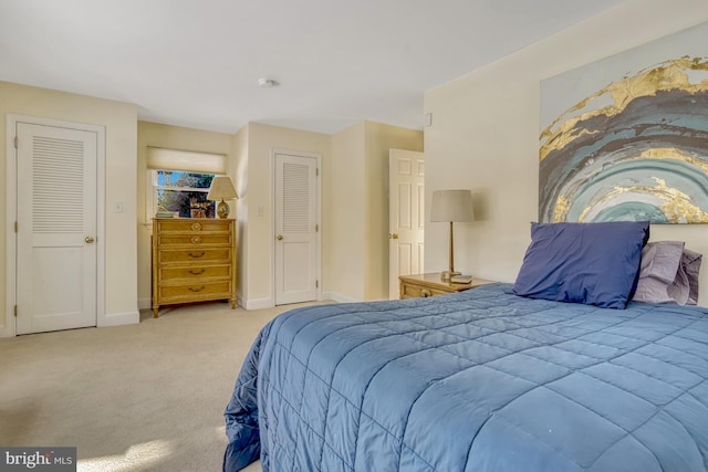 carpeted bedroom featuring two closets