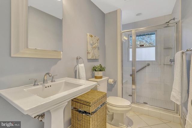 bathroom with sink, walk in shower, tile patterned flooring, and toilet