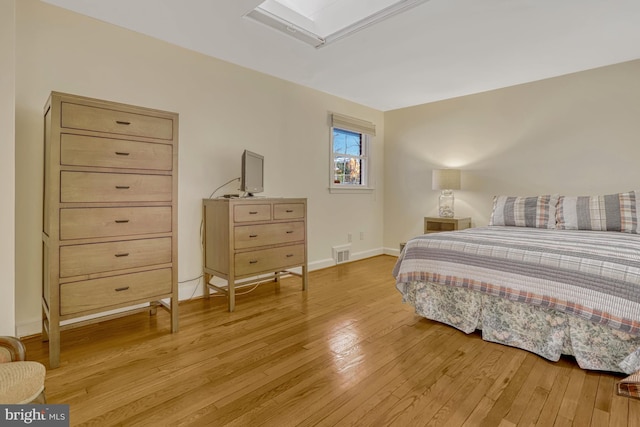 bedroom featuring light wood-type flooring and a skylight