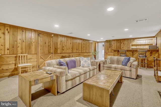 living room with wooden walls and light carpet