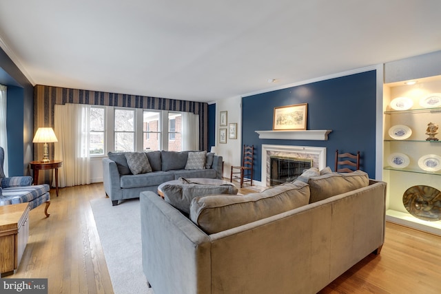 living room featuring a fireplace, built in features, and light hardwood / wood-style flooring