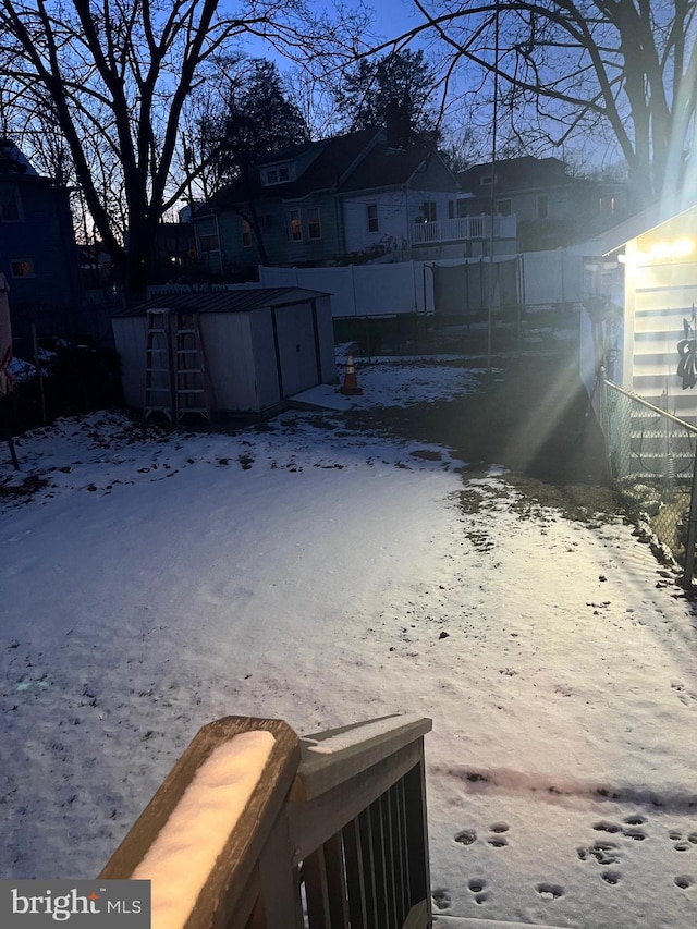 yard layered in snow with a shed