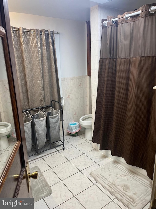 bathroom with tile patterned floors, toilet, and tile walls