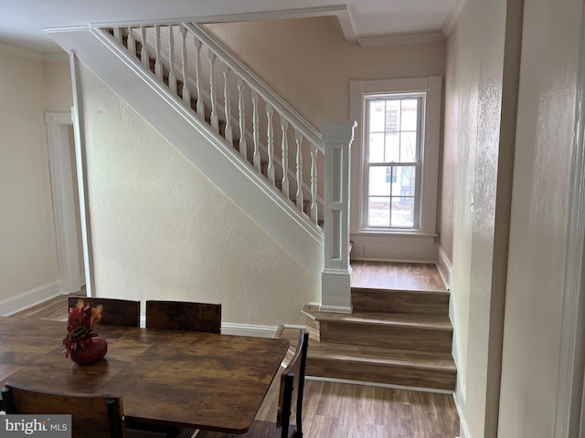 stairs featuring crown molding and wood-type flooring