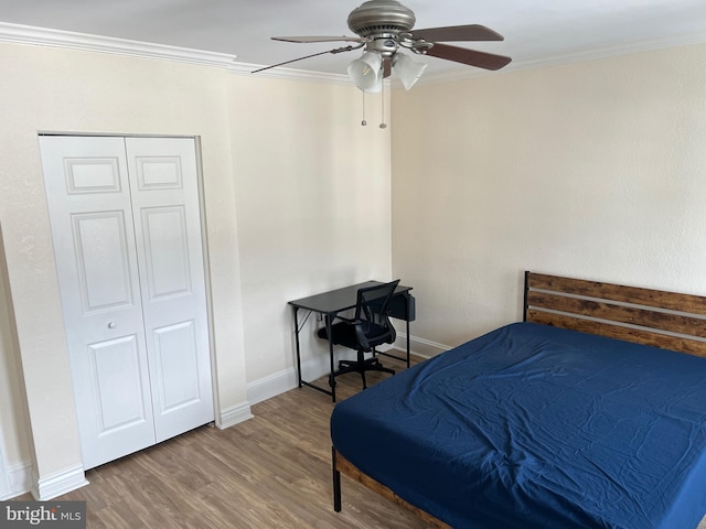 bedroom with hardwood / wood-style floors, a closet, ceiling fan, and ornamental molding