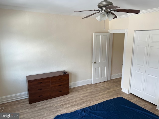 unfurnished bedroom featuring hardwood / wood-style floors, ceiling fan, crown molding, and a closet