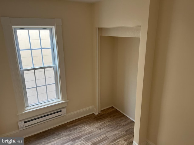 interior space with baseboard heating, plenty of natural light, and light hardwood / wood-style floors