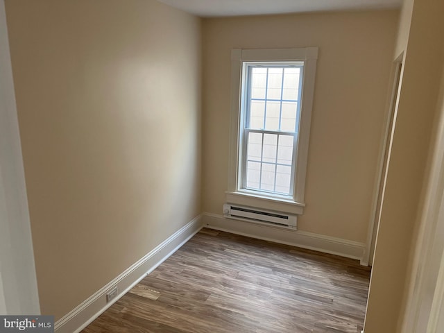 spare room featuring a baseboard radiator and light hardwood / wood-style floors