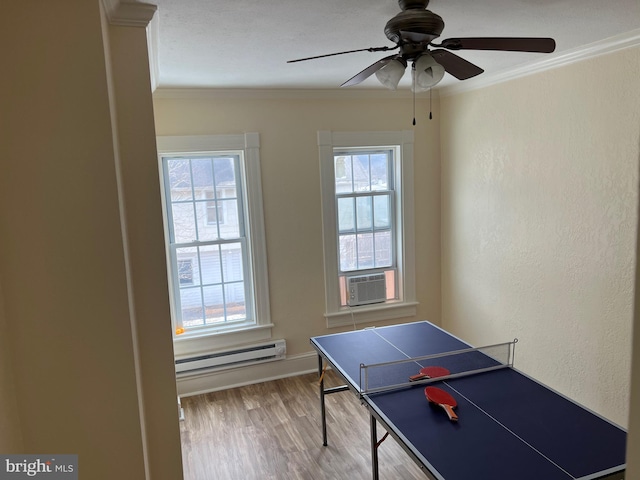 playroom with baseboard heating, a wealth of natural light, ceiling fan, and hardwood / wood-style flooring