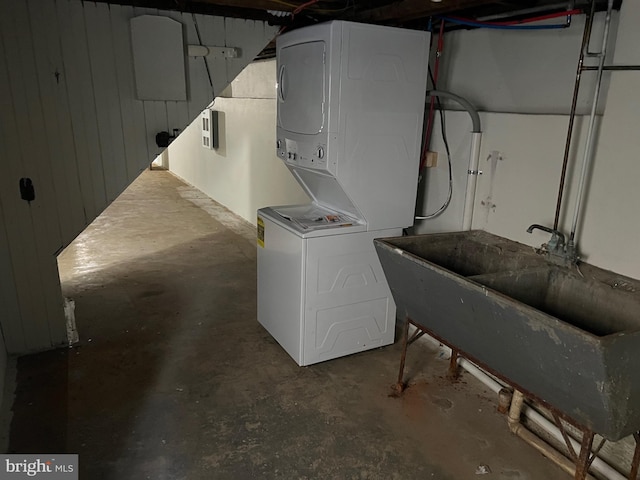 laundry room with wood walls and stacked washing maching and dryer