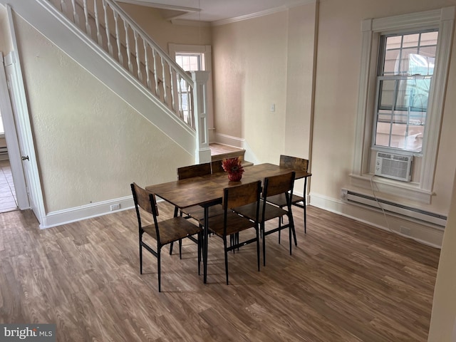 dining space with crown molding, hardwood / wood-style floors, a baseboard radiator, and plenty of natural light