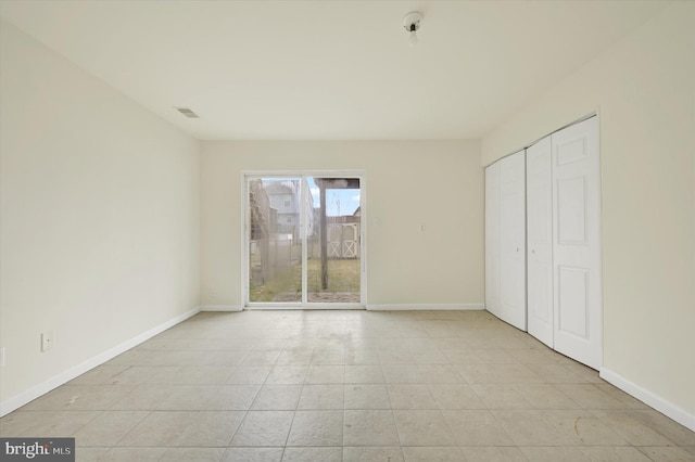 unfurnished bedroom featuring a closet, visible vents, baseboards, and access to outside