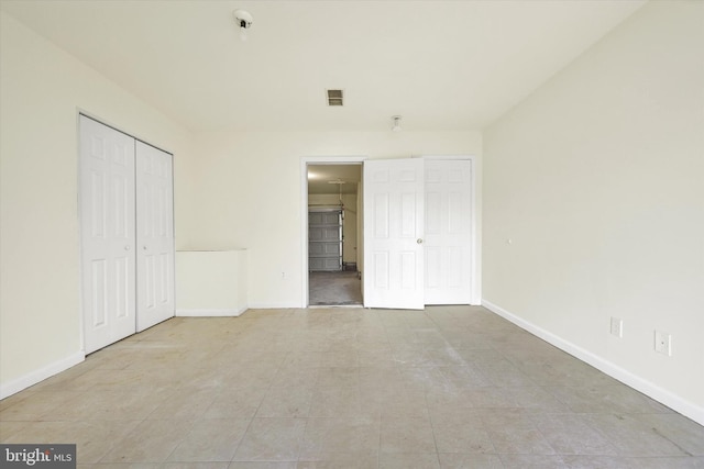 unfurnished bedroom with visible vents, baseboards, a closet, and connected bathroom