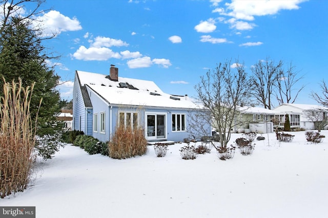 view of snow covered rear of property