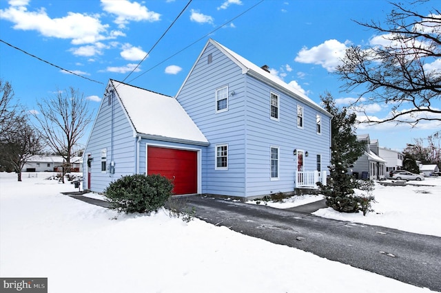 snow covered property featuring a garage