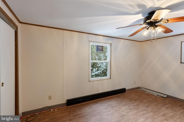 spare room with ceiling fan, wood-type flooring, crown molding, and a baseboard radiator