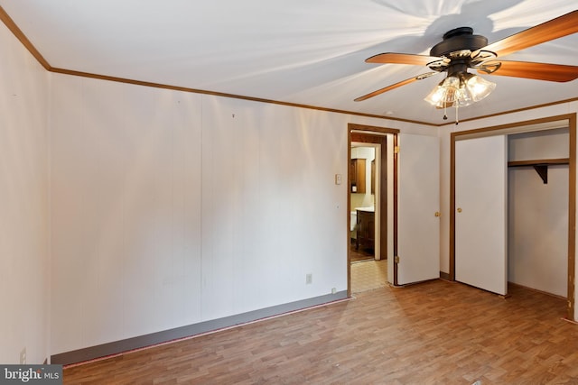 unfurnished bedroom with ceiling fan, light hardwood / wood-style floors, crown molding, and a closet