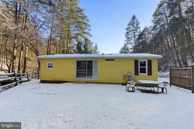 view of snow covered rear of property