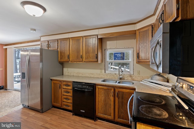 kitchen with crown molding, sink, stainless steel appliances, and light hardwood / wood-style floors