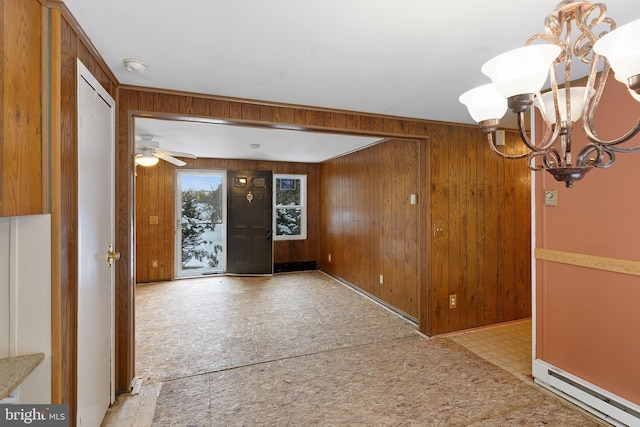 entryway featuring ceiling fan with notable chandelier, wooden walls, and a baseboard heating unit