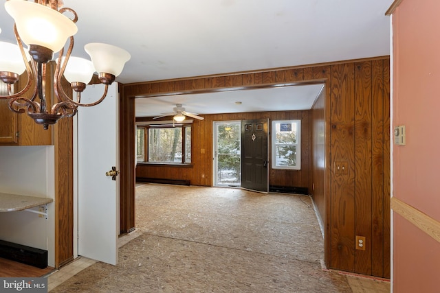 foyer featuring a baseboard heating unit, ceiling fan with notable chandelier, and wooden walls