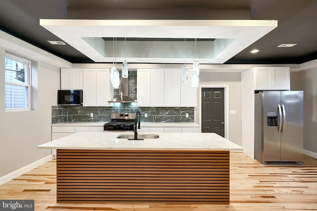 kitchen with a kitchen island with sink, white cabinets, hanging light fixtures, sink, and appliances with stainless steel finishes