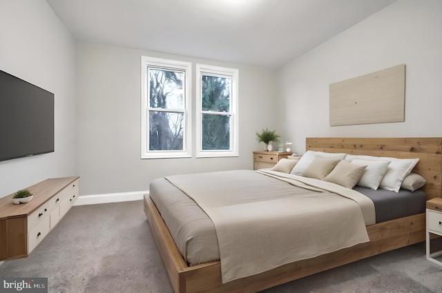 bedroom featuring dark colored carpet and lofted ceiling