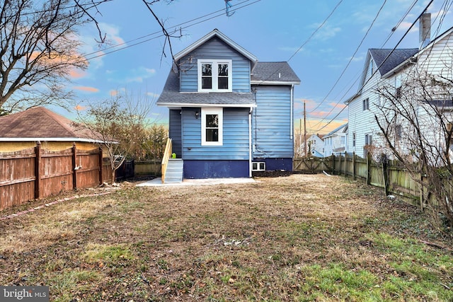 rear view of property featuring a lawn