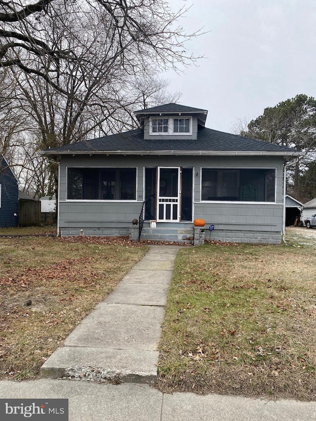 view of front facade featuring a front lawn and a sunroom