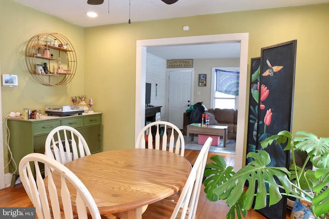 dining space with wood-type flooring and ceiling fan