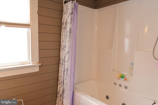 bathroom featuring wooden walls and shower / bath combo