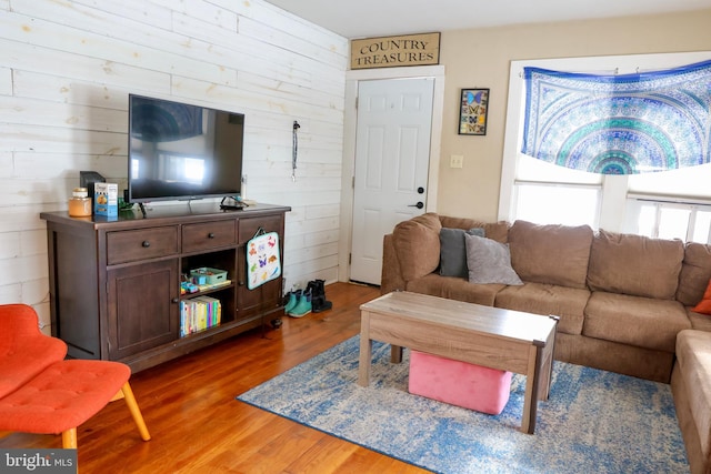 living room with wooden walls and wood-type flooring