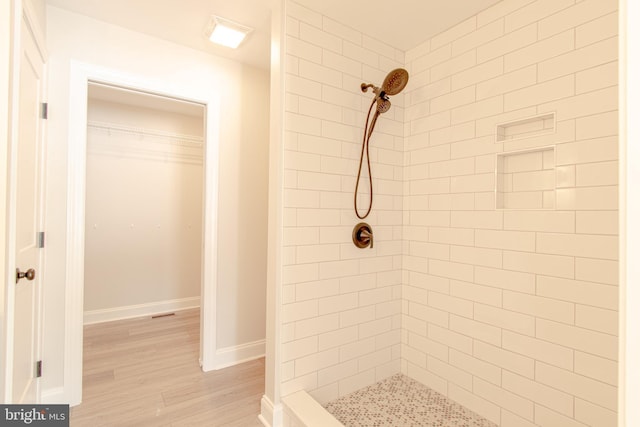 bathroom featuring a tile shower and hardwood / wood-style floors