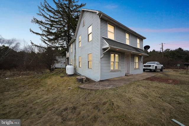 view of front of house featuring a yard and central AC