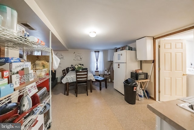 kitchen featuring white fridge and white cabinetry