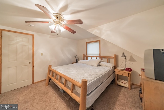 carpeted bedroom with ceiling fan and vaulted ceiling