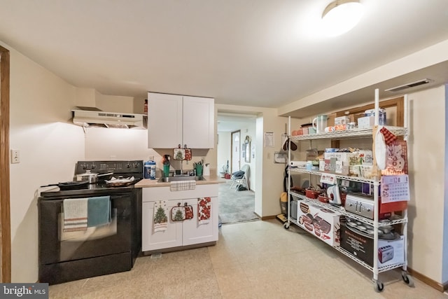 kitchen featuring black electric range and white cabinetry