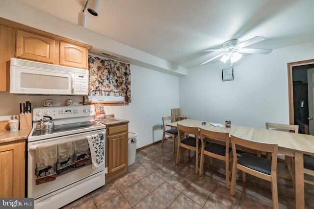 kitchen featuring dark tile patterned flooring, white appliances, and ceiling fan