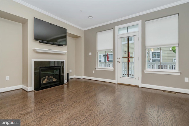 unfurnished living room featuring crown molding, a healthy amount of sunlight, dark hardwood / wood-style floors, and a tile fireplace