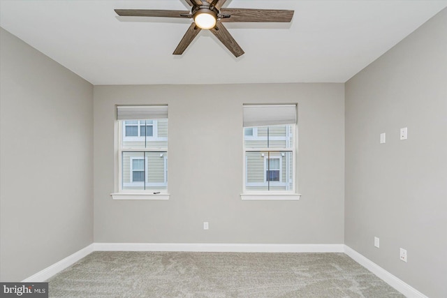 carpeted spare room with a wealth of natural light and ceiling fan