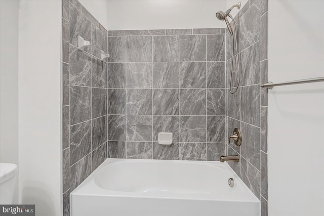 bathroom featuring tiled shower / bath and toilet