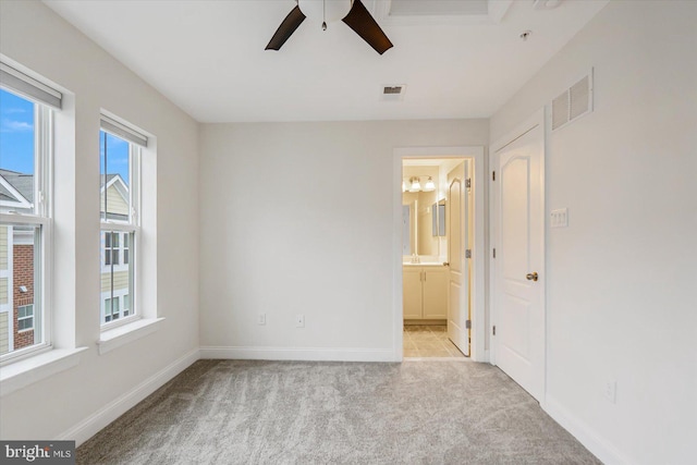 empty room with light colored carpet and ceiling fan