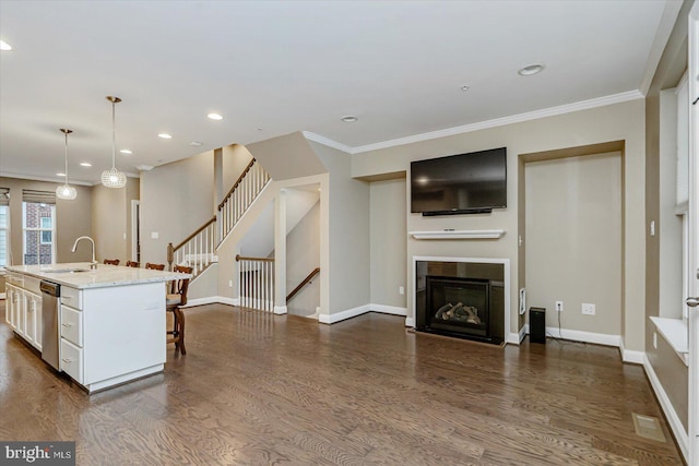 kitchen featuring a breakfast bar, decorative light fixtures, sink, a kitchen island with sink, and stainless steel dishwasher