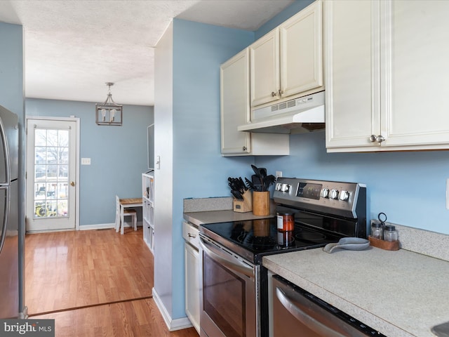 kitchen featuring light hardwood / wood-style flooring, appliances with stainless steel finishes, and pendant lighting