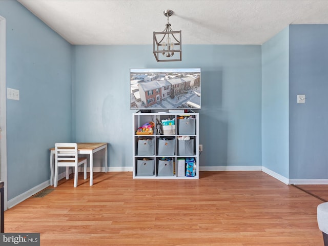 interior space featuring an inviting chandelier, a textured ceiling, and hardwood / wood-style floors