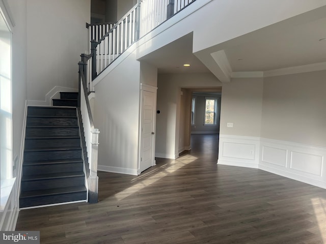 stairs with crown molding and wood-type flooring